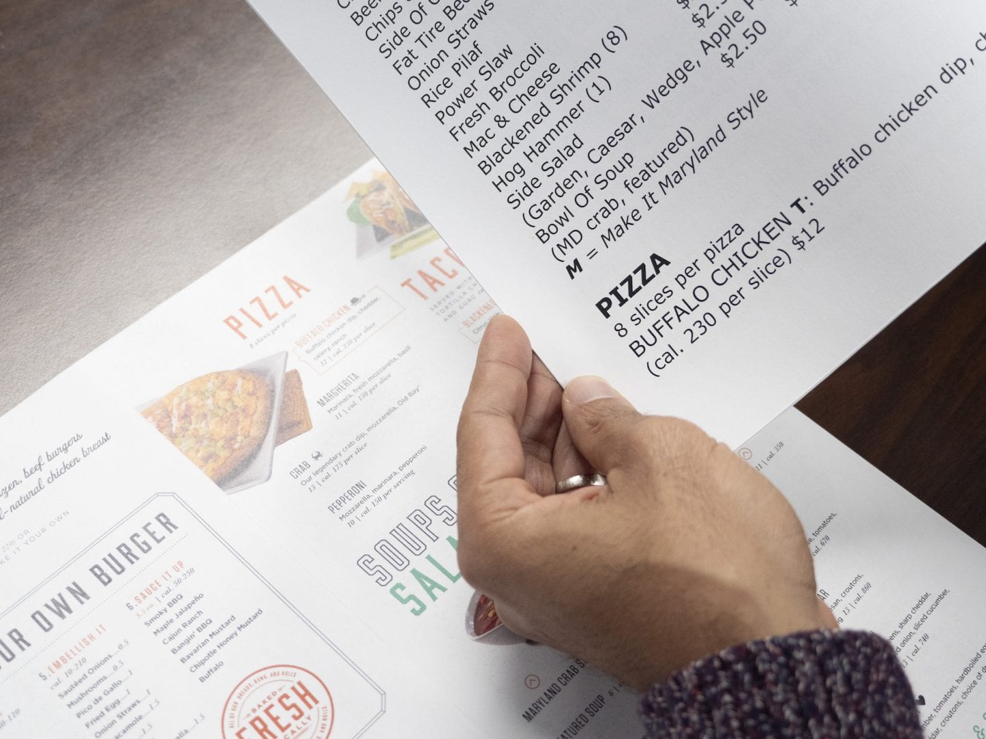 Hand holding large print insert of a menu