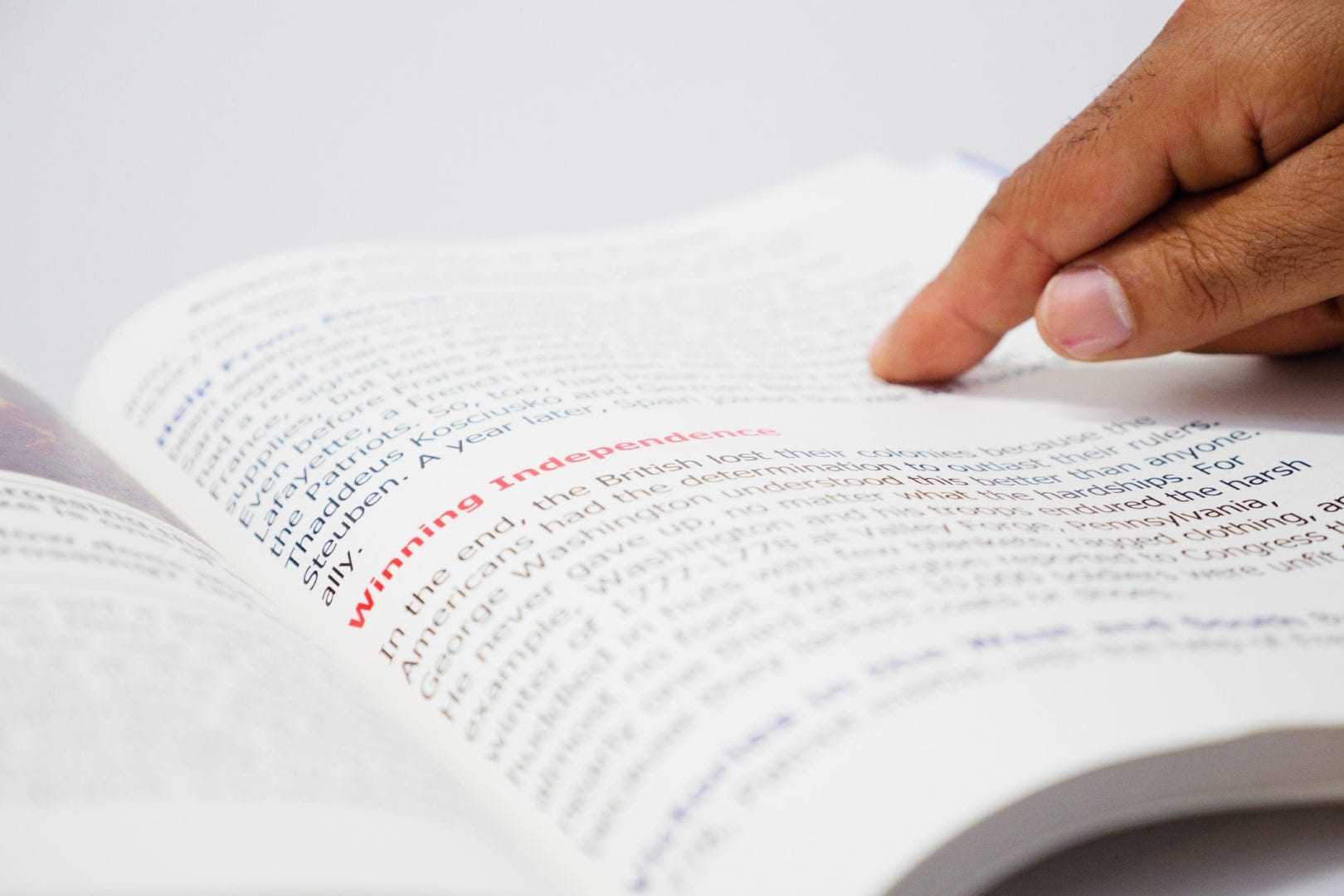 a hand tracking paragraphs on a book