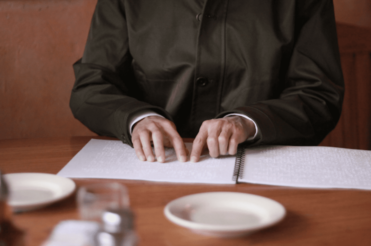 hands on a braille menu in a restaurant