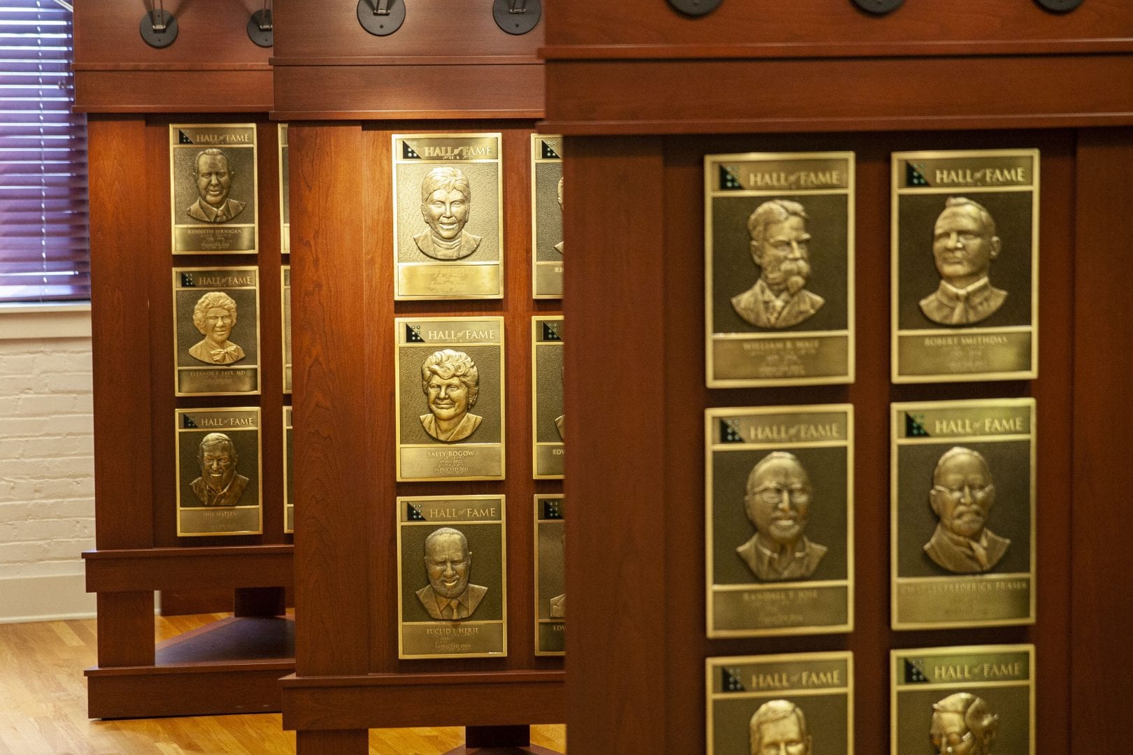 three wooden stands displaying bronze portrait plaques of hall of fame inductees