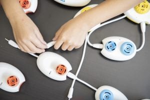 overview of kids hands plugging together a network of pods