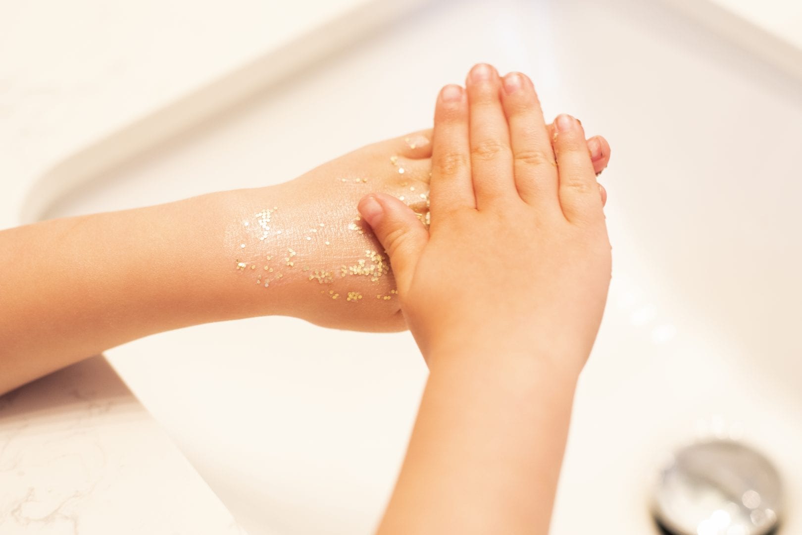 a child rubbing glitter on their hands