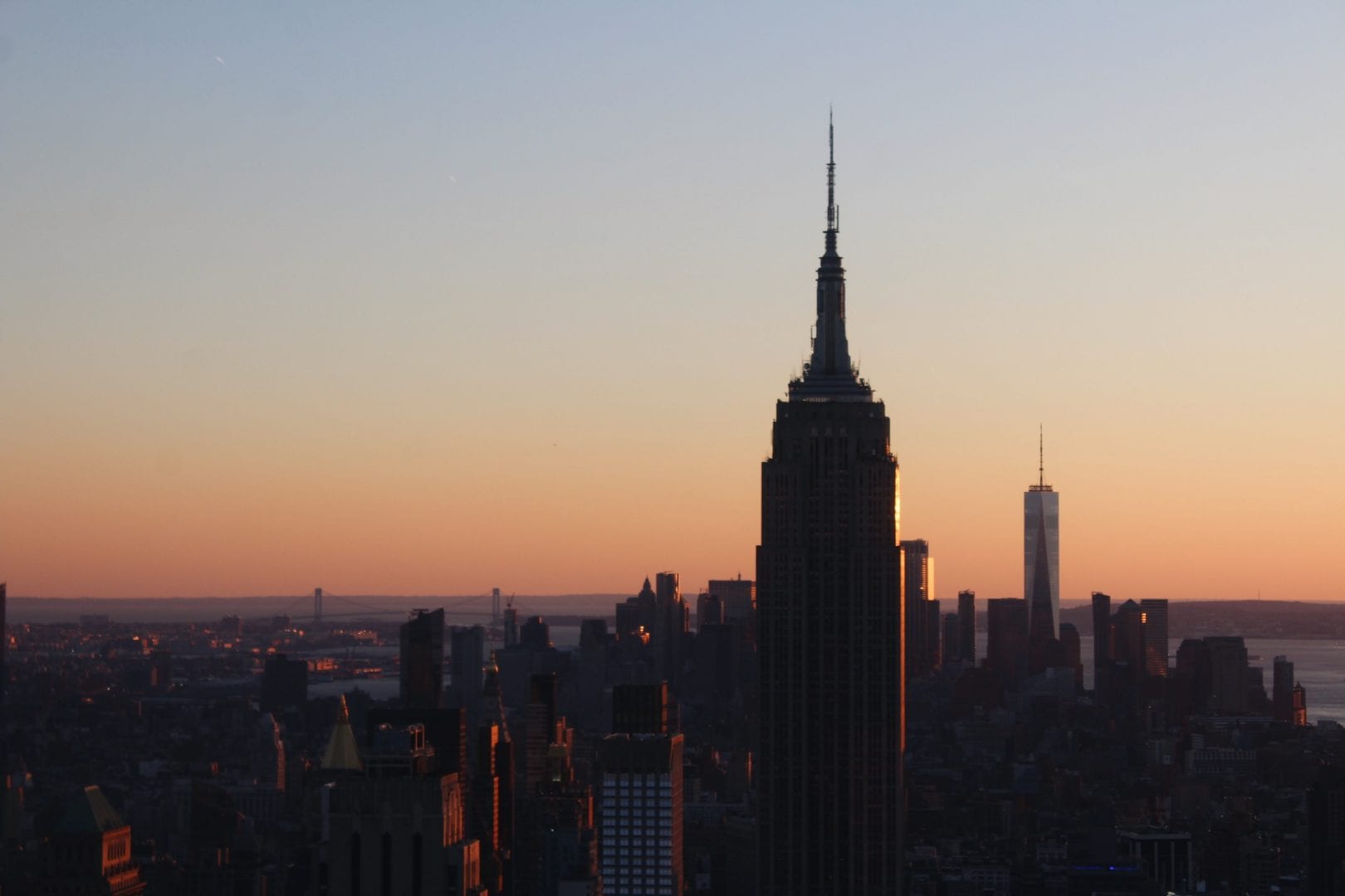 a skyline with a tower prominently shown at sunset