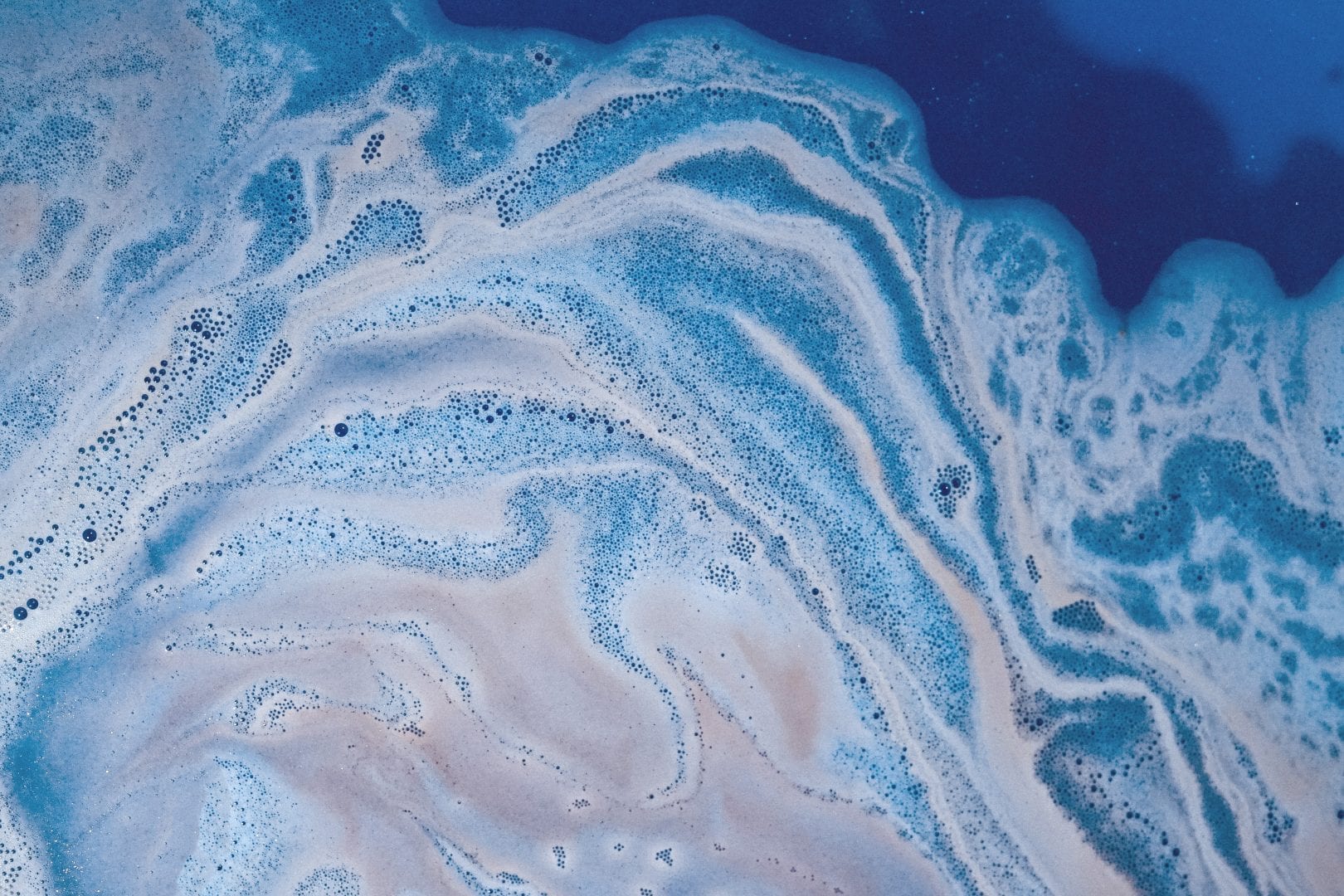 a swirl of a white liquid and a blue liquid like oil on water