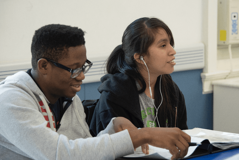 two teenage students in a classroom setting