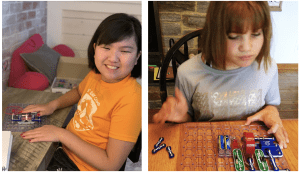Side by side photos of students with snap circuits jr kits.student on the left smiles at the camera while pressing the button on the board that makes the propeller spin and light come on. student on the right assembles pieces at a kitchen table.