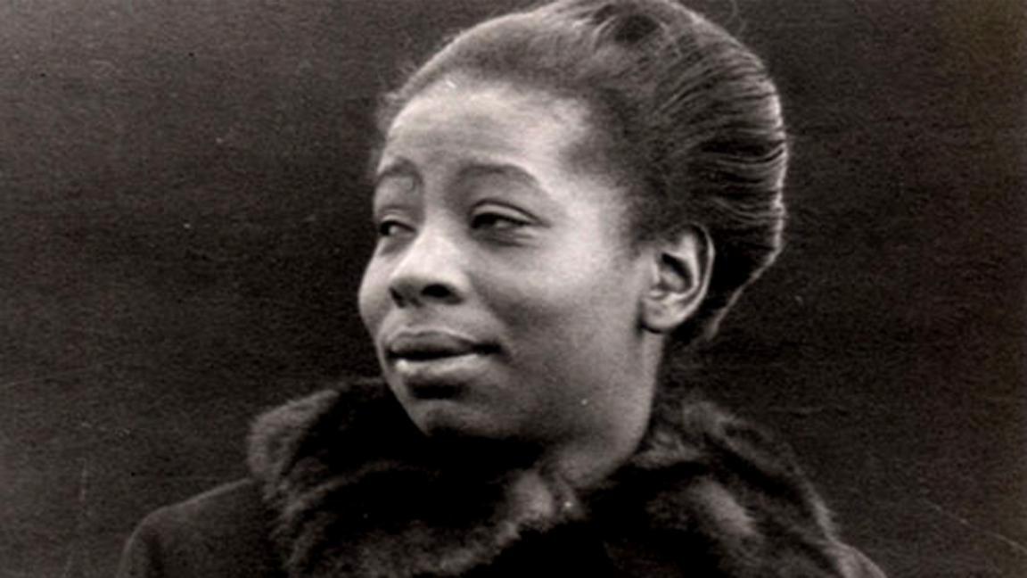 A head and shoulders photo of a young Black woman wearing a jacket with a fur collar.